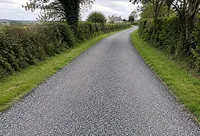 A tar and chip private lane between hedgerows