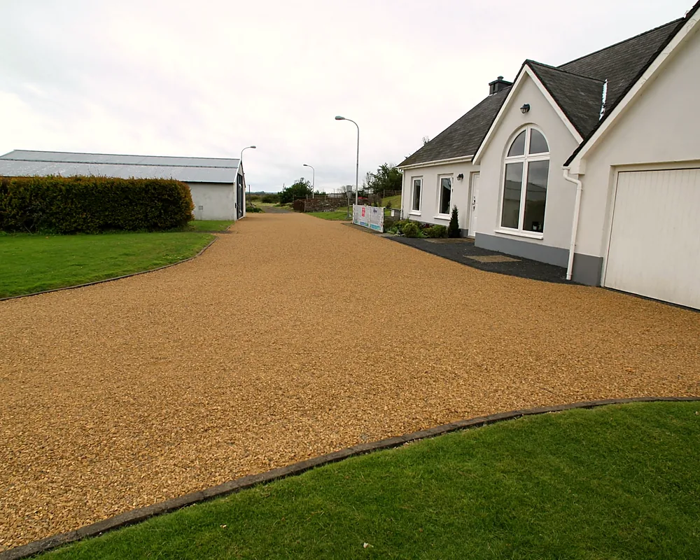 A gravel driveway and turning area at a detached house
