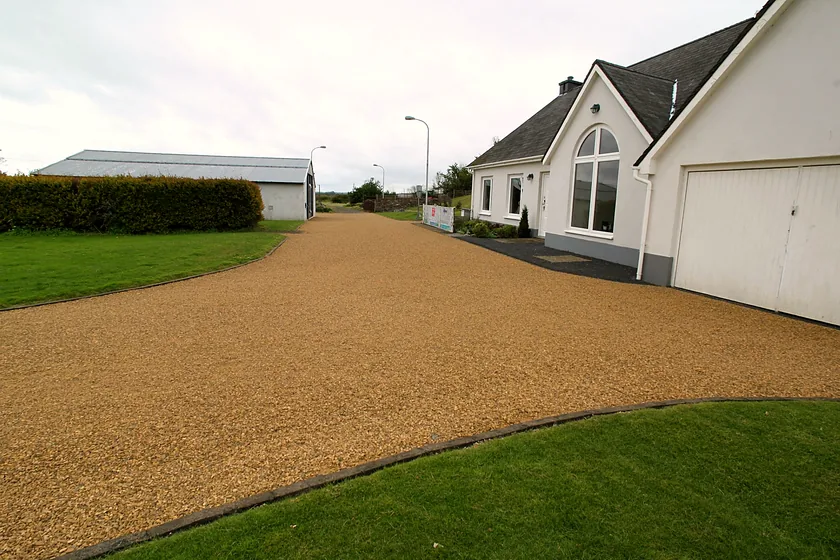 A gravel driveway and turning area at a detached house