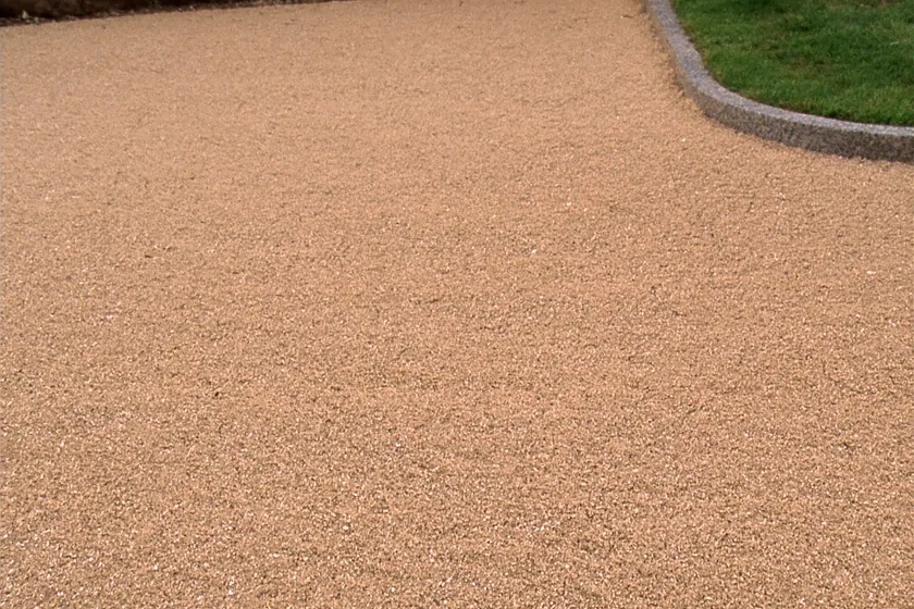 A resin bound path meeting a kerb and lawn