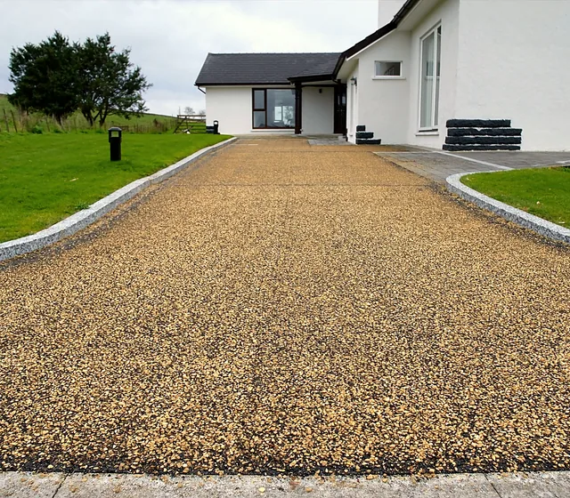 A tar and chip driveway at a white country house