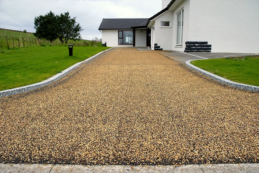 A tar and chip driveway at a white country house