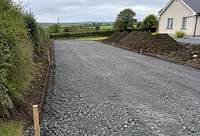 A cleared site with a stone base laid for a new driveway