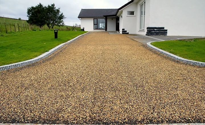 A tar and chip driveway at a white country house